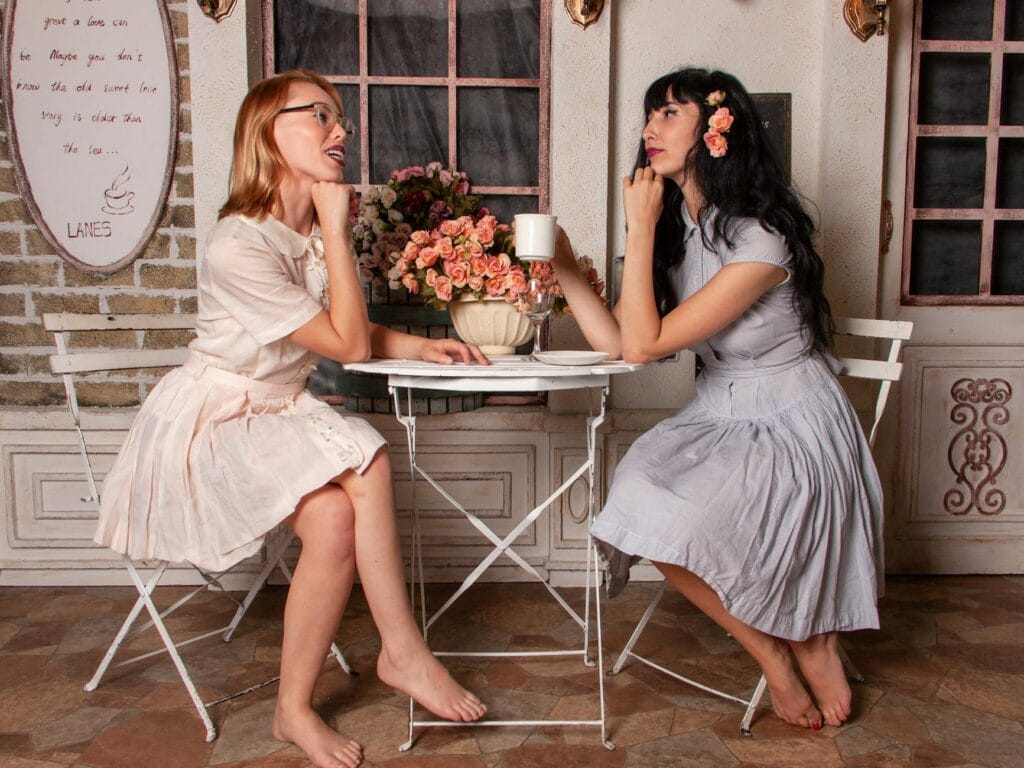 two women talking while drinking coffee
