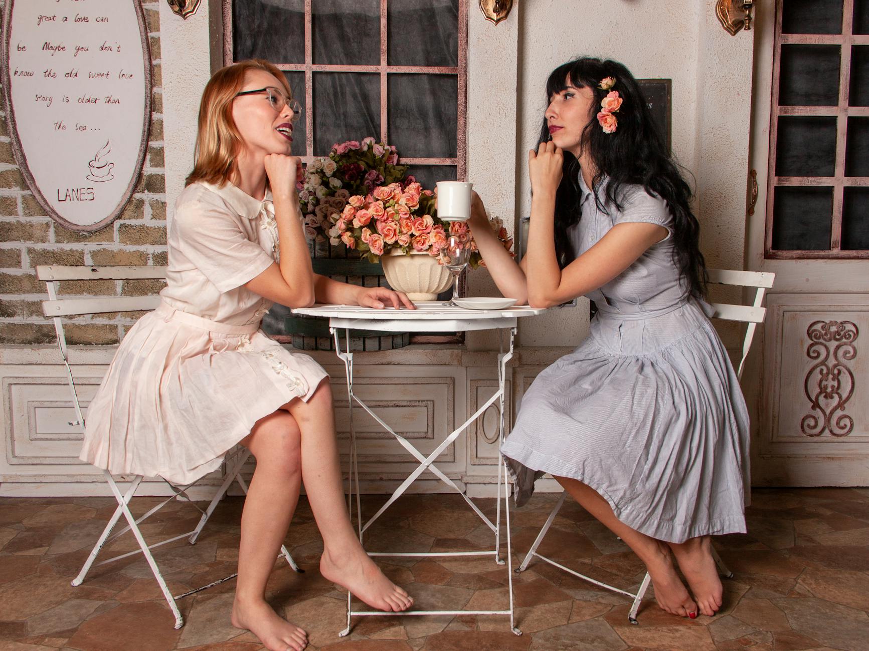 two women talking while drinking coffee